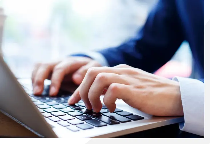 Person typing on laptop keyboard.